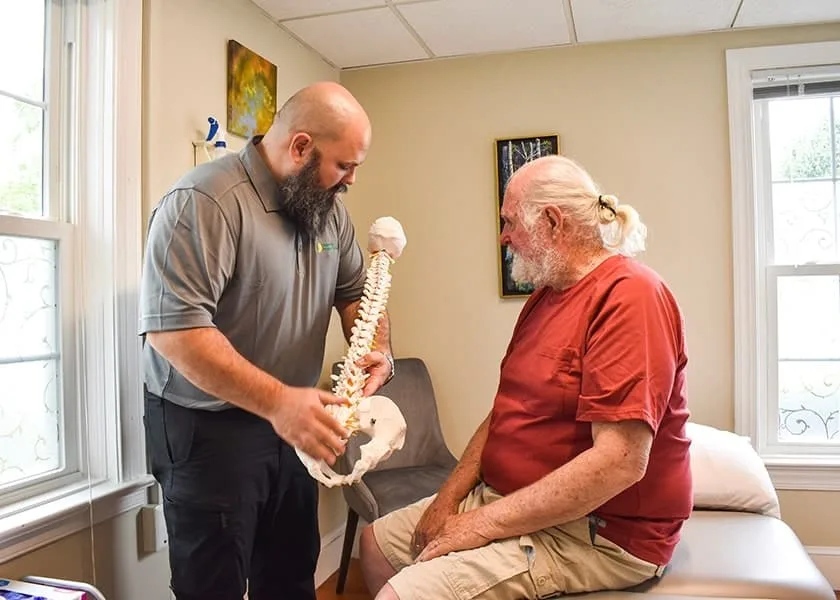Doctor of Physical Therapy educating a patient during treatment