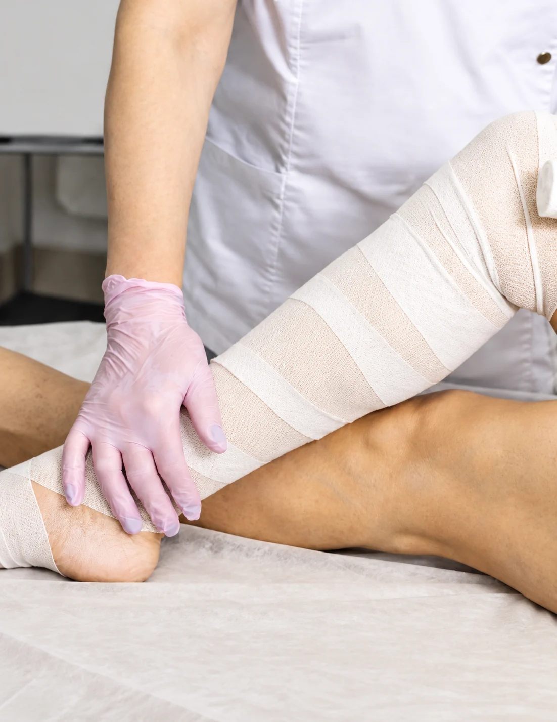 Clinician applying a compression wrap during lymphedema therapy