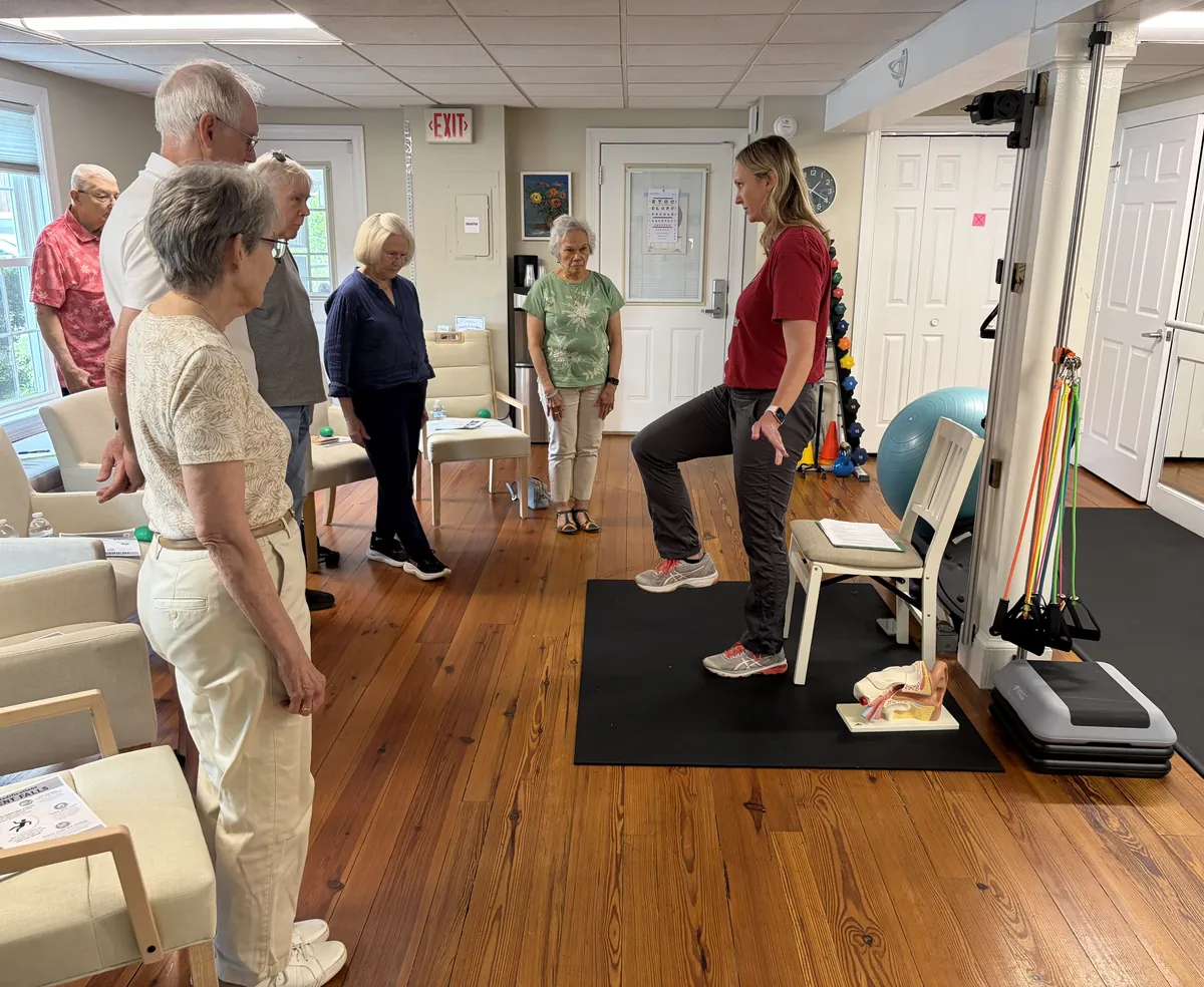 Physical therapist leading a balance and fall-prevention workshop for a group of participants