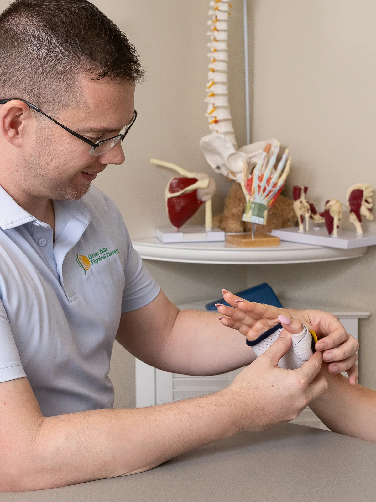 Hand therapist working on a patient's hand and wrist mobility during a therapy session