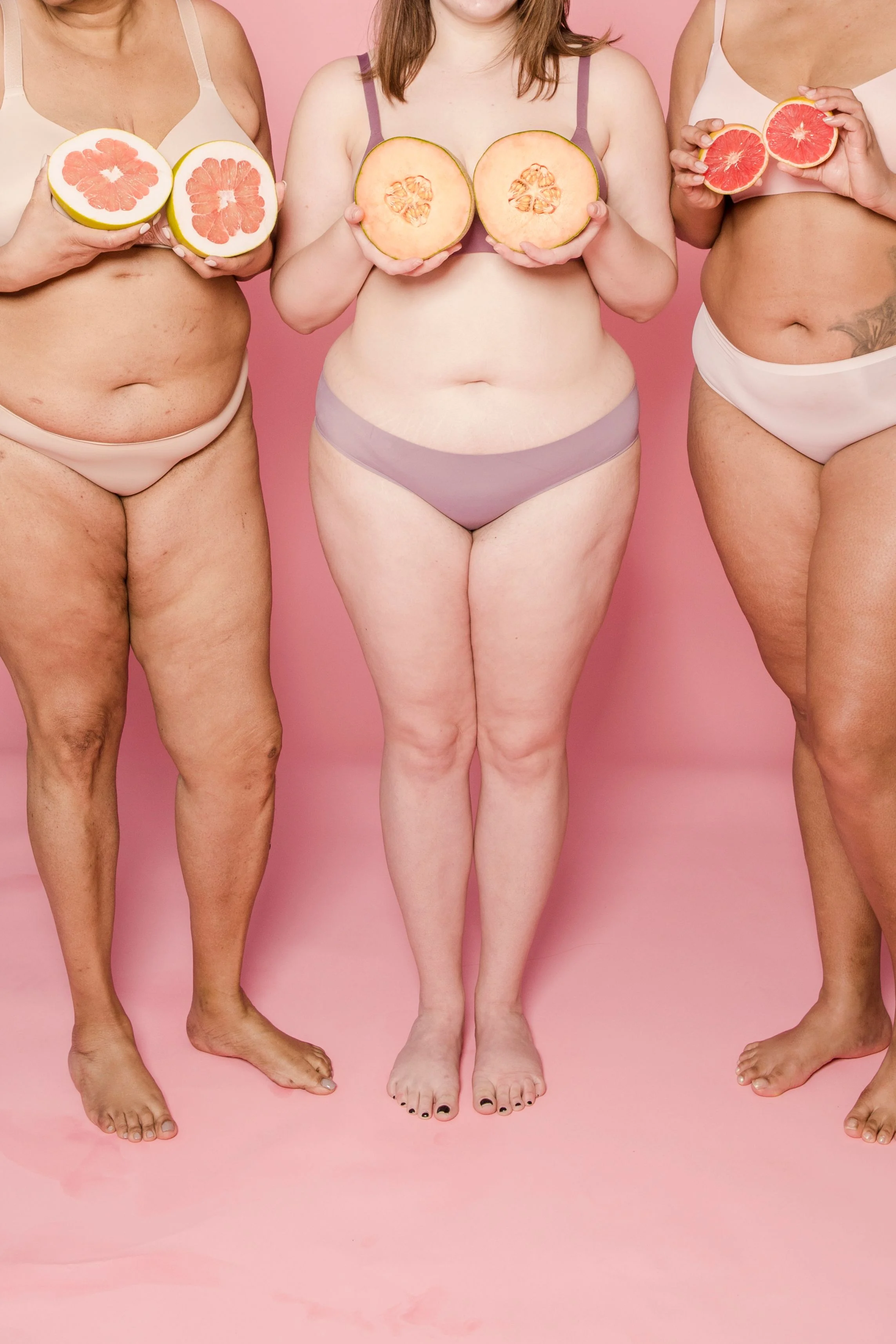 Pregnant women holding fruit as a visual for women's pelvic health